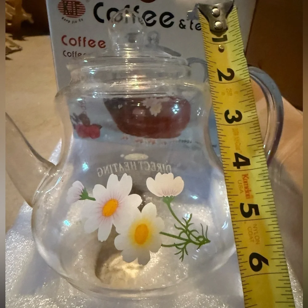 Glass tea pot about 6 inches tall including the lid has decorative yellow flower